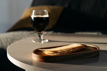 Potato chips and glass with beer on background