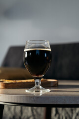 Still life shot of glass with dark beer on marble table