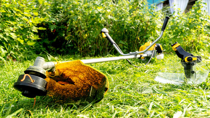 Grass trimmer on mowed lawn