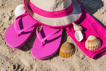 Accessories for relax on beach. Straw hat, flip flop and towel. Summertime
