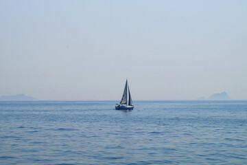 small sailing yacht at sea against the background of the sea horizon