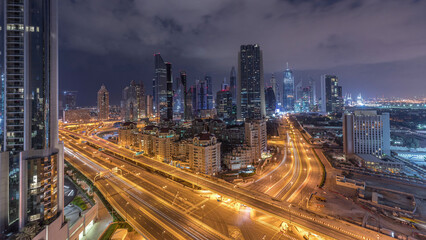 Skyline view of the buildings of Sheikh Zayed Road and DIFC night to day timelapse in Dubai, UAE. - obrazy, fototapety, plakaty