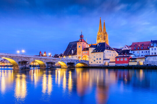 Regensburg, Bavaria, Germany. Cathedral of St. Peter and the Stone Bridge over the Danube river at night.
