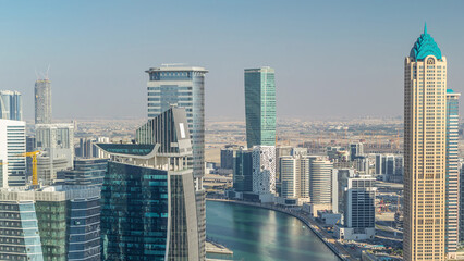 Naklejka premium Aerial skyline of Dubai's business bay with skyscrapers timelapse before sunset.