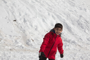 Niño jugando en la nieve, vacaciones de invierno