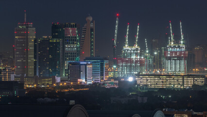 Aerial cityscape with architecture of Dubai downtown night to day timelapse, United Arab Emirates.