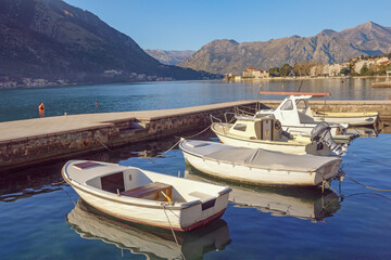 Fototapeta na wymiar Beautiful Mediterranean landscape. Boats on water on sunny winter day. Montenegro, Adriatic Sea, Bay of Kotor near Dobrota town