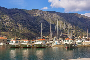 Fototapeta na wymiar Boats and sailboats in port near Old Town of Kotor. Beautiful Mediterranean landscape. Montenegro, Adriatic Sea, Bay of Kotor
