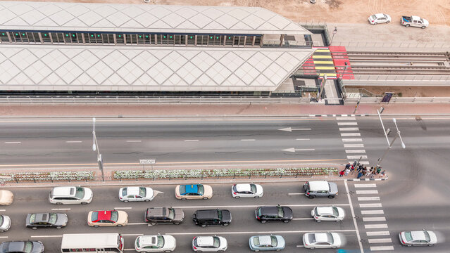 Intersection with cars and tram stop with railway aerial view from above timelapse in Dubai Marina