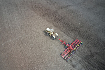 Pre-sowing soil preparation. Tractor with trailed combined tillage machine working on the field....