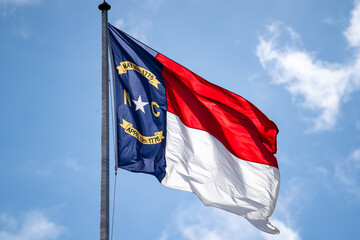 North Carolina State Flag Waving In The Wind, Close-up Photo, Blue sky, sunny.