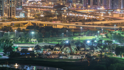 Golf course and Dubai Marina illuminated skyscrapers night timelapse, Dubai, United Arab Emirates