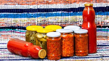 Glass jars with pickled red bell peppers and pickled cucumbers (pickles) isolated. Jars with...