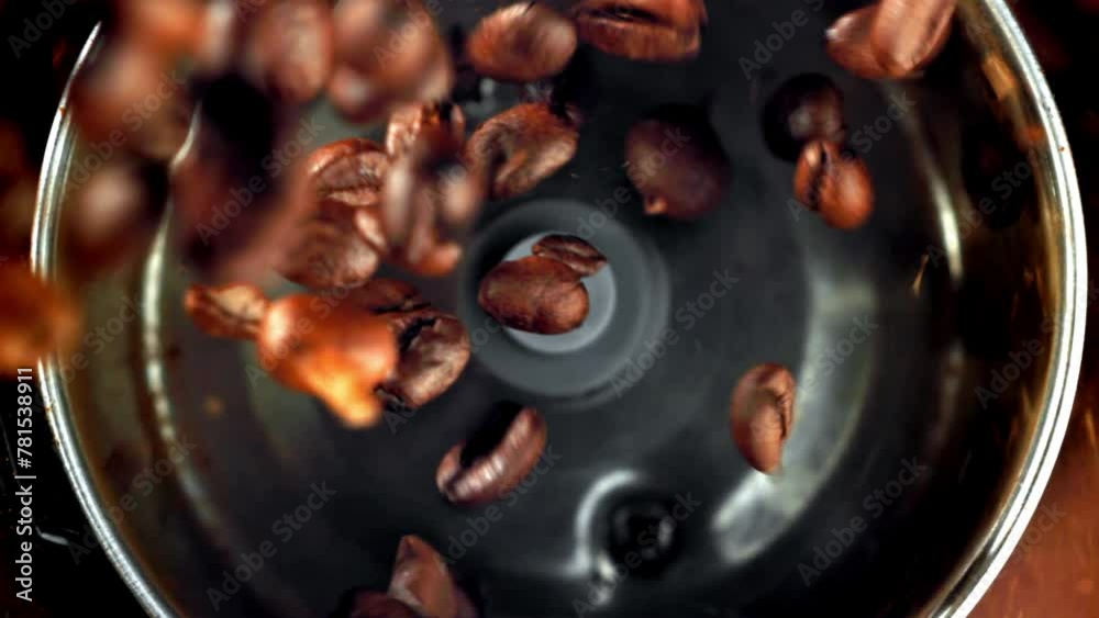 Wall mural super slow motion coffee beans in a working grinder. high quality fullhd footage