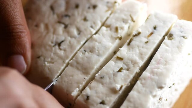 close up of cutting fresh cheese on a chopping background.