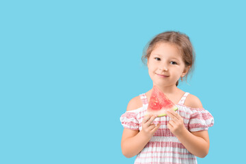 Happy little girl with slice of fresh watermelon on blue background