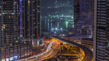 Fototapeta na wymiar Aerial view to Dubai marina skyscrapers with construction site and Palm Jumeirah Island on background night timelapse.