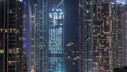 View of various skyscrapers and towers in Dubai Marina from above aerial night timelapse