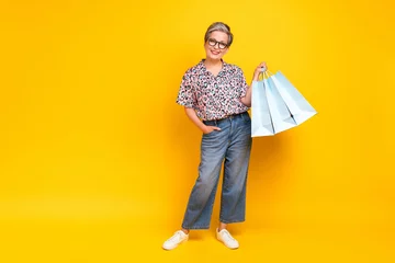 Foto op Plexiglas Full length photo of lovely senior lady hold shopping bags dressed stylish leopard print garment isolated on yellow color background © deagreez