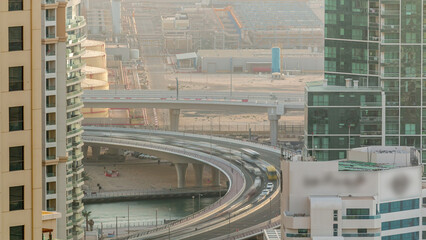 Traffic on the bridge at JBR and Dubai marina during sunset aerial timelapse.