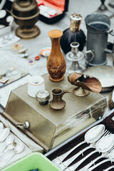 Flea market stall with old and vintage crockery, antique copper teapots and copper goods. Brass...