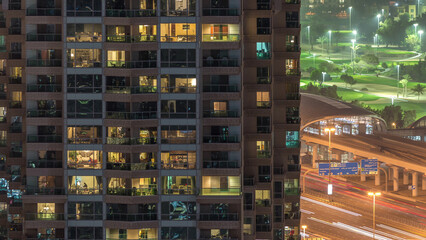 Fototapeta na wymiar Lights in windows of modern multiple story building in urban setting at night timelapse