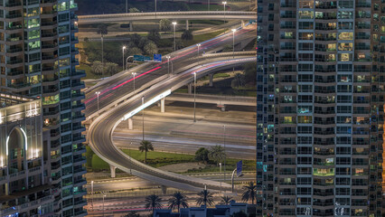 Dubai Marina highway exit between skyscrapers, spaghetti junction aerial night timelapse