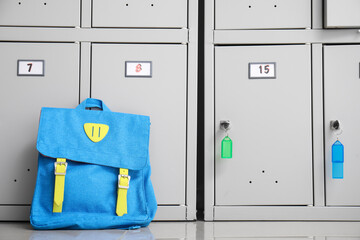 Backpack near locker at school, closeup