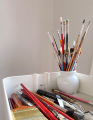 Paint brushes, spatula and artist material in a studio. Art supplies. Creative tools in a mobile cart.