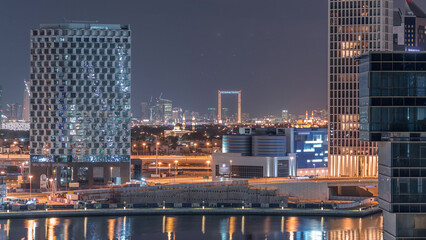 Bright night in Dubai near canal aerial timelapse