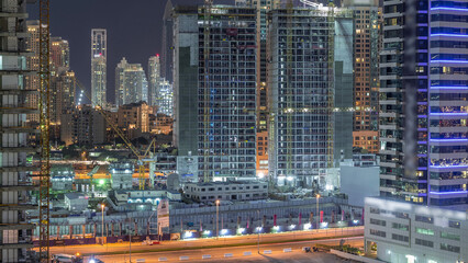 Fototapeta na wymiar Aerial view of constructing with cranes night timelapse in Dubai.