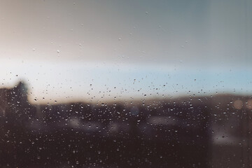 Drops of rain on glass after rain. Rain drops on window glasses surface with cloudy sunset...