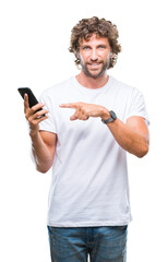 Handsome hispanic man model sending message texting using smartphone over isolated background very happy pointing with hand and finger