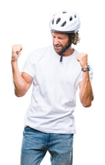 Handsome hispanic cyclist man wearing safety helmet over isolated background very happy and excited doing winner gesture with arms raised, smiling and screaming for success. Celebration concept.