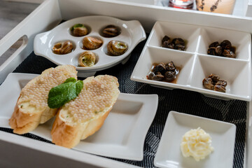 Set of baked snails and snail caviar with bread. Gourmet food