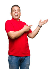 Middle age arab man over isolated background amazed and smiling to the camera while presenting with hand and pointing with finger.