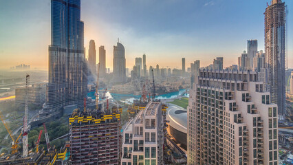 Panoramic skyline view of Dubai downtown during sunrise with mall, fountains and Burj Khalifa...