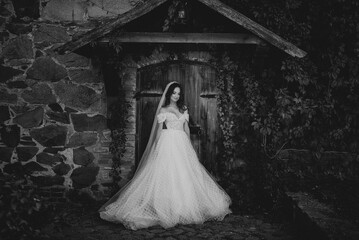 Bride in a wedding dress standing in front of a wooden door
