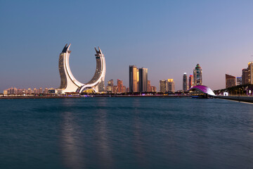 Crescent tower from Al Maha Island in Qatar, with a brightly blue sky before sunset . Lusail, Qatar