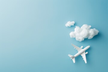 Naklejka na ściany i meble Model airplane with clouds on blue background.