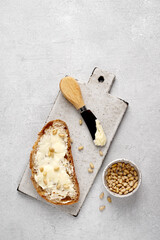 Spreading butter onto bread with knife on board, healthy breakfast, copy space , top view