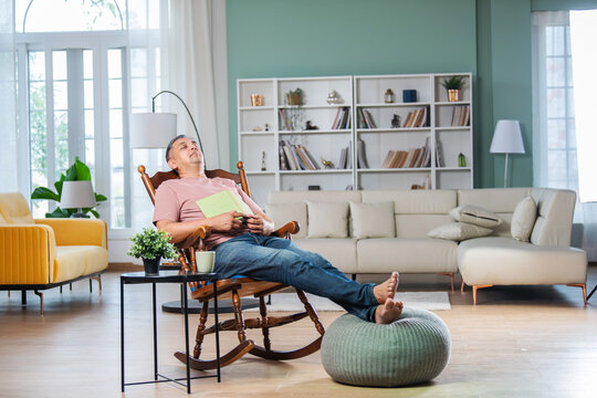 sian Indian handsome man with grey hair enjoy reading book at home or taking a nap