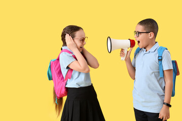 Funny little pupils with backpacks and megaphone screaming on yellow background