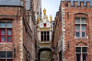 Foto auf Alu-Dibond White bridge over a street in Brugge, with gold sculptures and red windows. © Andreas