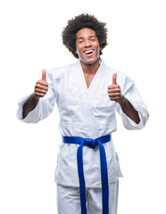 Afro american man wearing karate kimono over isolated background success sign doing positive...