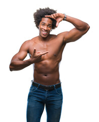 Fototapeta premium Afro american shirtless man showing nude body over isolated background smiling making frame with hands and fingers with happy face. Creativity and photography concept.