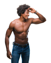 Naklejka premium Afro american shirtless man showing nude body over isolated background very happy and smiling looking far away with hand over head. Searching concept.
