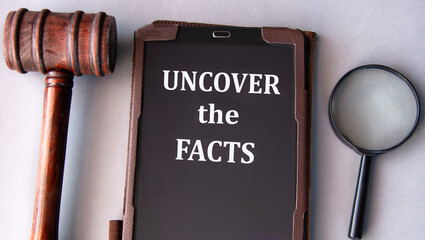 UNCOVER THE FACTS - words on an electronic notepad with a judge's gavel in the background