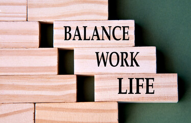 BALANCE WORK LIFE - words on wooden blocks on dark green background