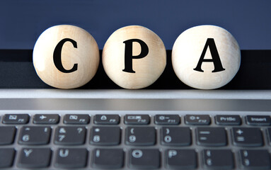 CPA - acronym on wooden balls on laptop keyboard background